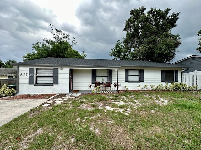 5127 Glasgow Ave, Orlando, FL 32819 - ranch-style home with fence, a shingled roof, a porch, and a front yard