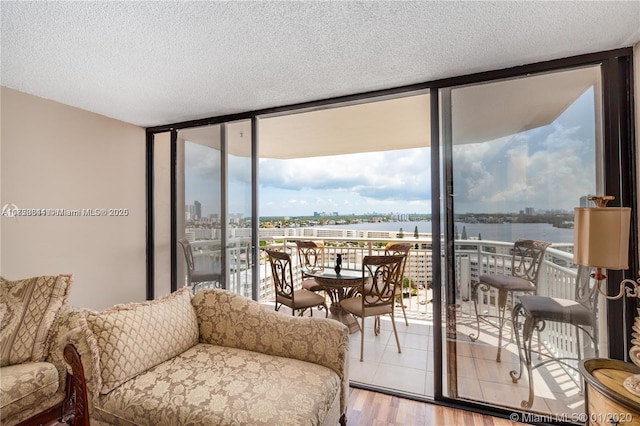 living area featuring a textured ceiling, tile patterned floors, a view of city, and expansive windows