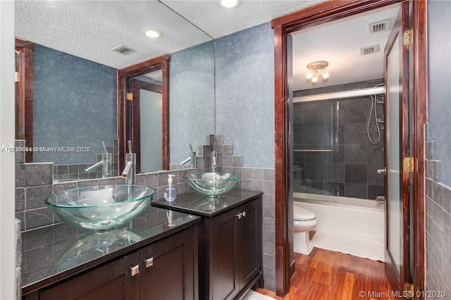 bathroom featuring vanity, tile walls, wood finished floors, and visible vents