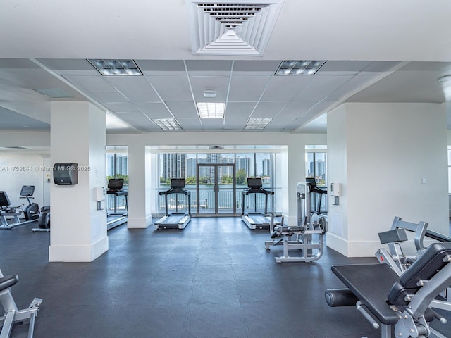 exercise room with a drop ceiling and baseboards