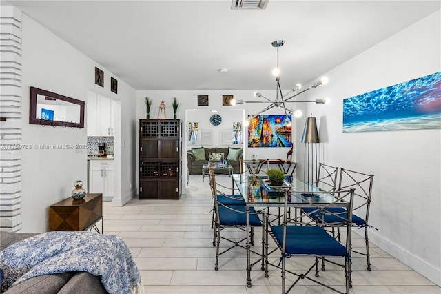 dining area featuring visible vents, baseboards, and a notable chandelier