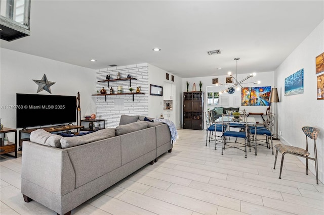 living room featuring visible vents, recessed lighting, light wood-style flooring, and an inviting chandelier