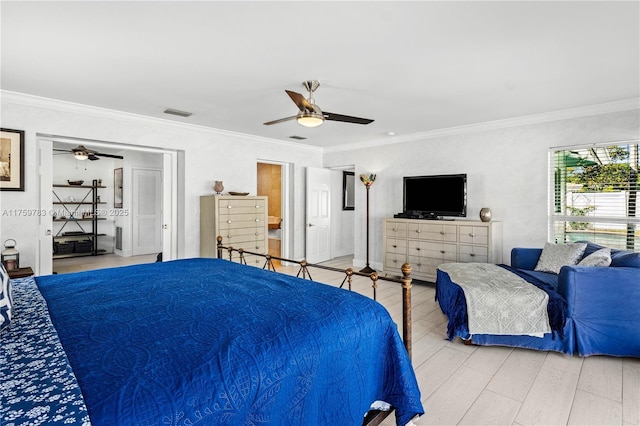 bedroom featuring visible vents, wood finished floors, a ceiling fan, and ornamental molding