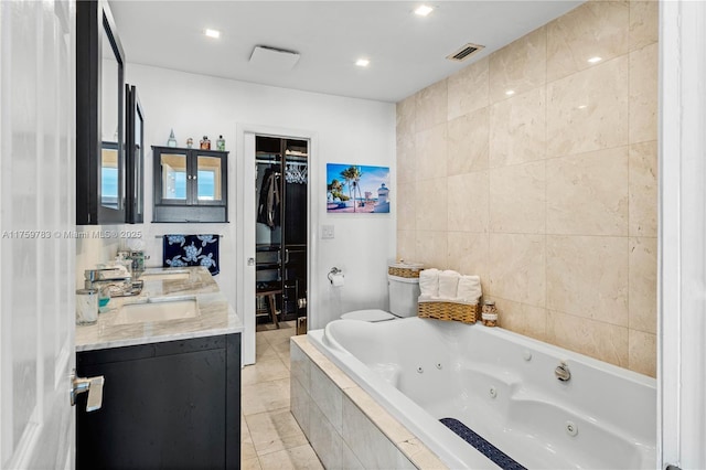 bathroom with visible vents, a walk in closet, a jetted tub, tile patterned flooring, and double vanity