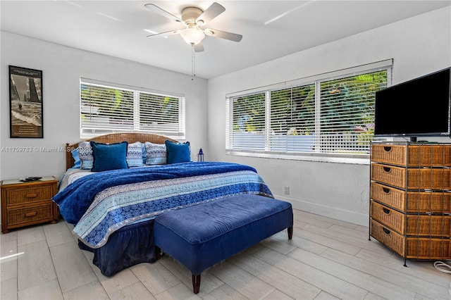 bedroom with ceiling fan, baseboards, and wood finished floors