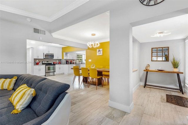 living area featuring light wood-type flooring, visible vents, and crown molding