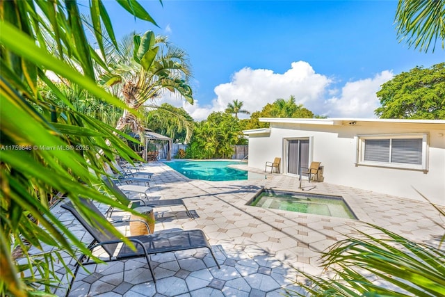 outdoor pool with a gazebo, a patio area, an in ground hot tub, and fence