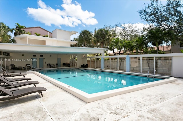 community pool with a patio and fence