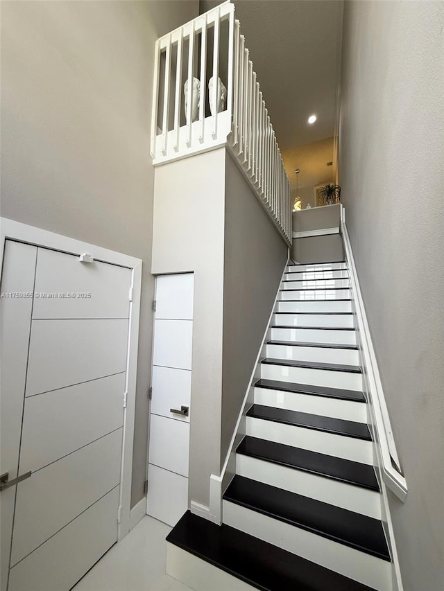 stairway with recessed lighting and baseboards