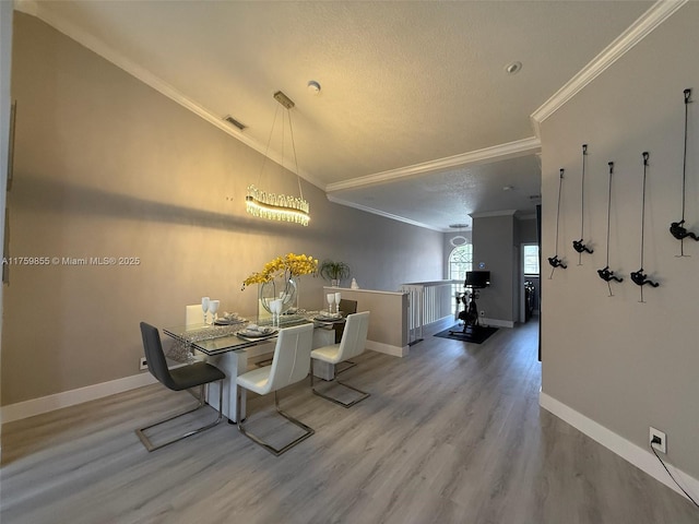 dining space featuring ornamental molding, visible vents, baseboards, and wood finished floors