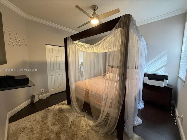 bedroom featuring a closet, ornamental molding, a ceiling fan, wood finished floors, and baseboards