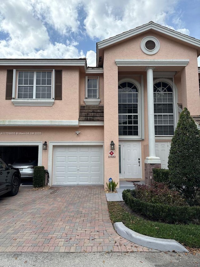 view of front of property with a garage, decorative driveway, and stucco siding