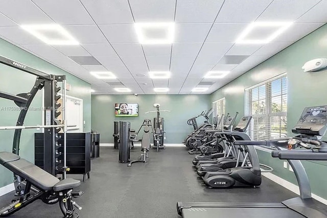 workout area with a drop ceiling and baseboards