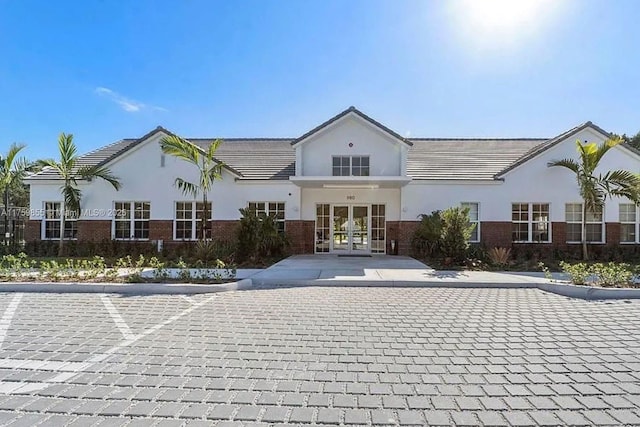 view of front facade with french doors and brick siding