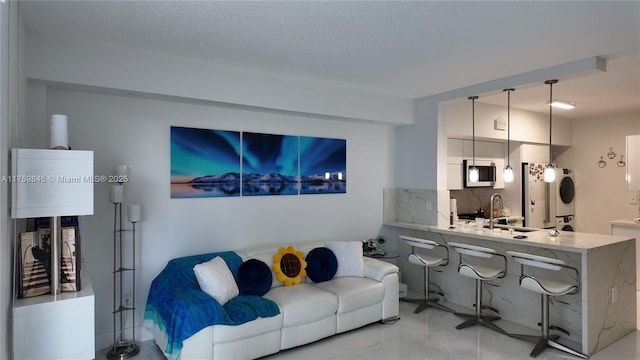 living room featuring stacked washer / drying machine and a textured ceiling