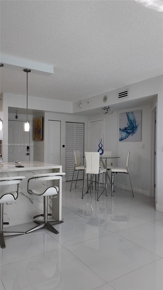 dining room featuring visible vents and a textured ceiling