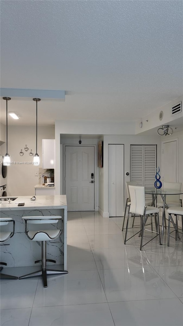 dining space featuring visible vents and a textured ceiling