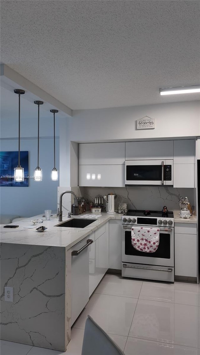 kitchen featuring modern cabinets, stainless steel range, a sink, white cabinetry, and white dishwasher