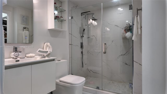 full bath with a marble finish shower, toilet, and vanity