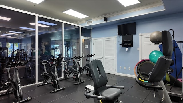 exercise room with visible vents and ornamental molding