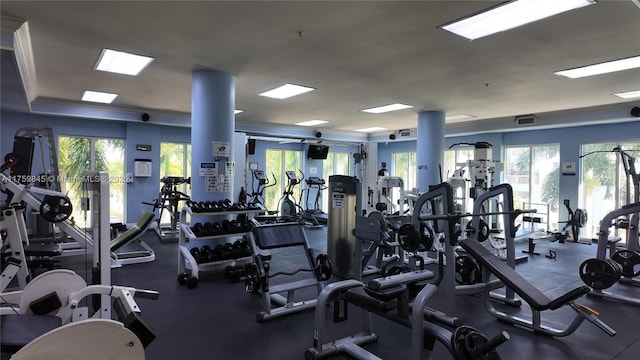 exercise room with visible vents and ornamental molding