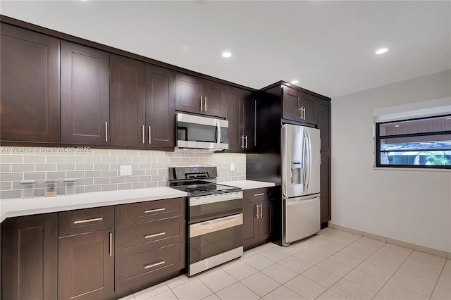 kitchen featuring stainless steel appliances, light countertops, backsplash, and dark brown cabinets