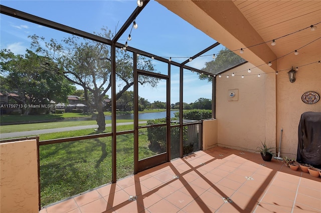 unfurnished sunroom with a water view and vaulted ceiling