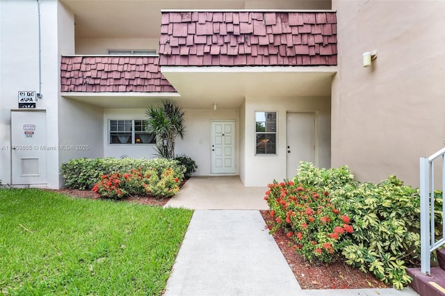 property entrance with mansard roof and stucco siding