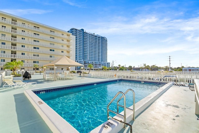 pool with a patio area and fence