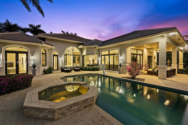 view of swimming pool featuring a patio area, french doors, and a pool with connected hot tub