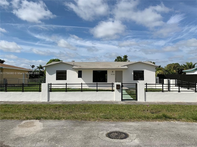 view of front facade with a fenced front yard, stucco siding, and a gate