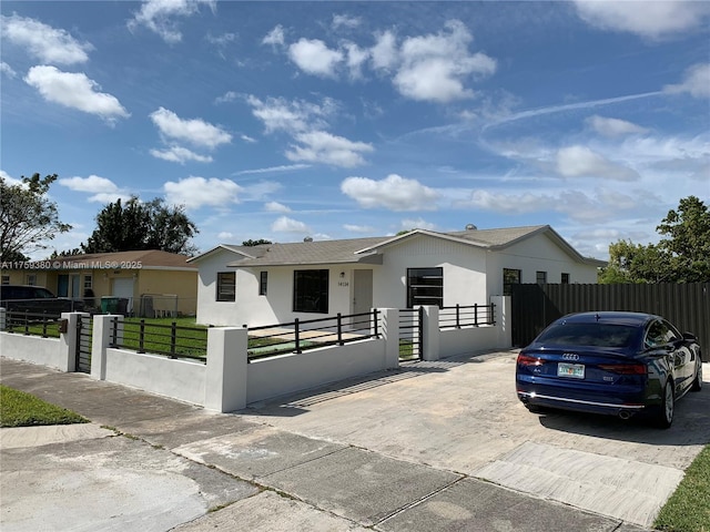 view of front of home featuring a gate, a fenced front yard, and stucco siding