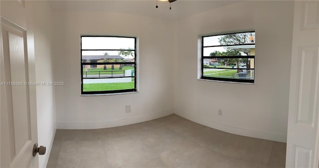 spare room with plenty of natural light and baseboards