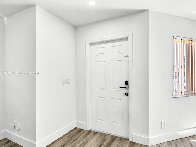 entryway with baseboards and wood finished floors