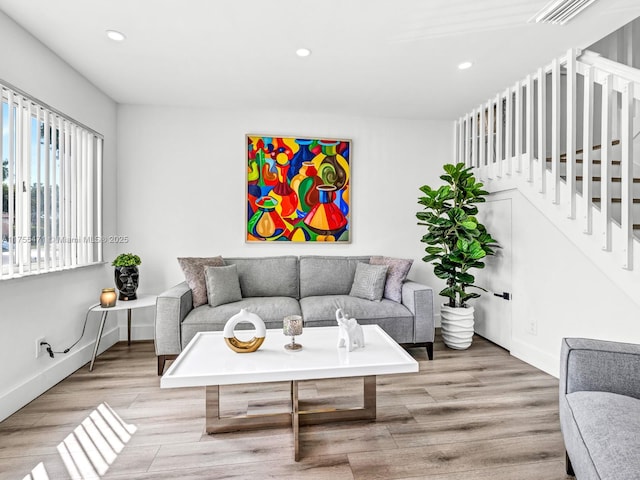 living area with visible vents, wood finished floors, recessed lighting, baseboards, and stairs