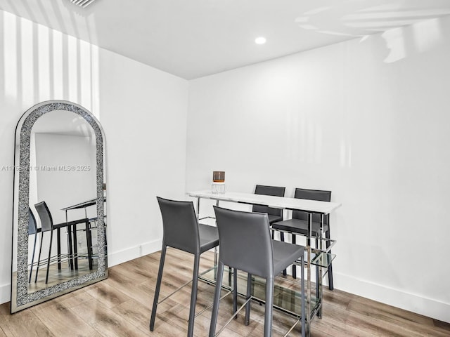 dining space featuring recessed lighting, baseboards, and wood finished floors