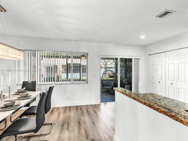 dining room with visible vents, light wood-type flooring, and baseboards