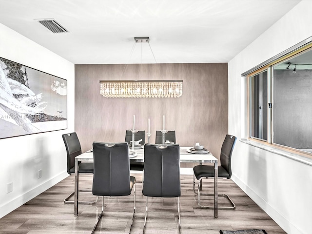 dining area with visible vents, baseboards, and wood finished floors