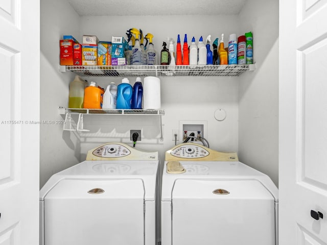 washroom with laundry area, washing machine and dryer, and a textured ceiling