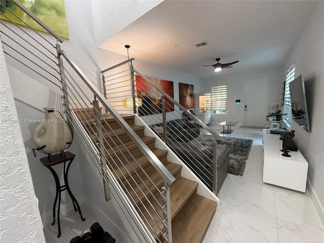 staircase with visible vents, marble finish floor, baseboards, and a ceiling fan