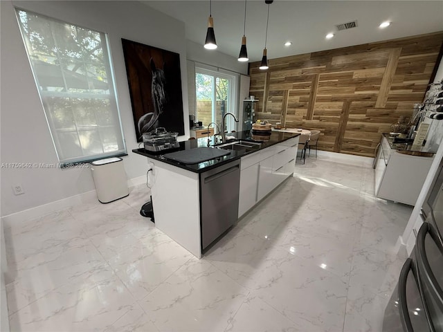 kitchen featuring a sink, wood walls, dishwasher, dark countertops, and marble finish floor