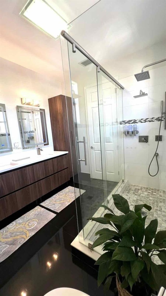 bathroom with a shower stall and vanity