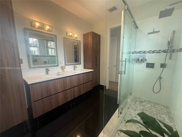 full bath with visible vents, double vanity, a sink, tile patterned flooring, and a shower stall