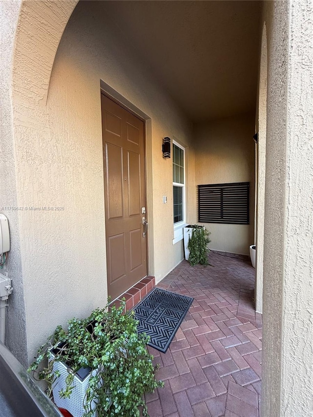 property entrance with stucco siding