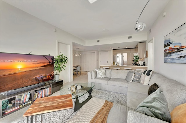 living area featuring visible vents and an inviting chandelier