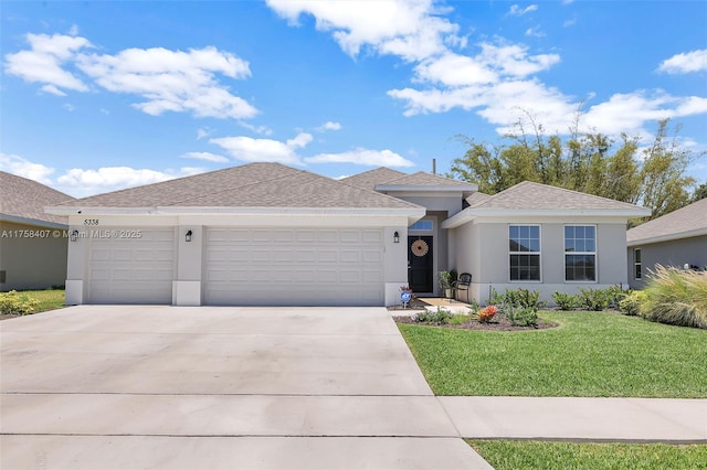 view of front facade with stucco siding, a front lawn, and a garage