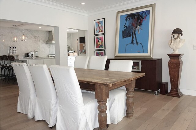 dining room with ornamental molding, recessed lighting, and light wood-style floors