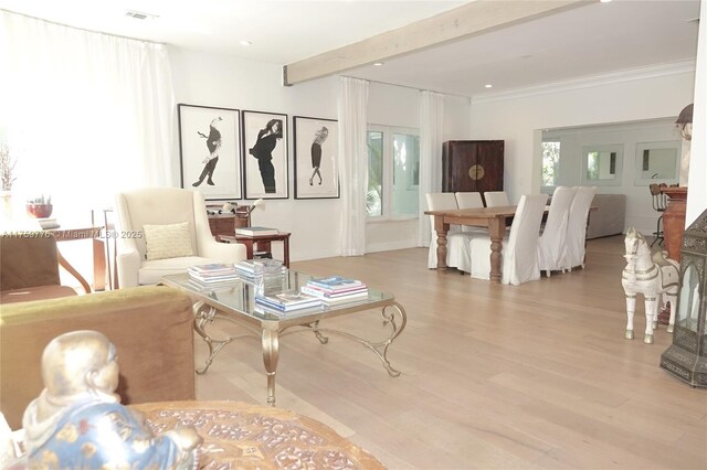 sitting room featuring plenty of natural light, visible vents, wood finished floors, and beamed ceiling