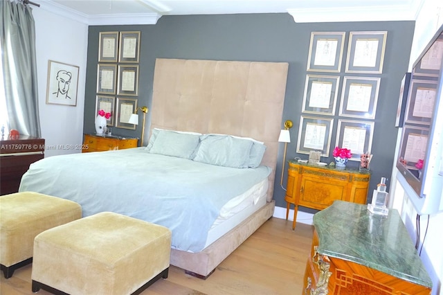 bedroom with ornamental molding and wood finished floors