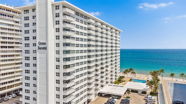 view of property featuring a water view and a beach view